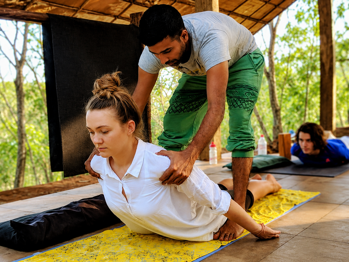 Instructor guiding trainee through a supported pose