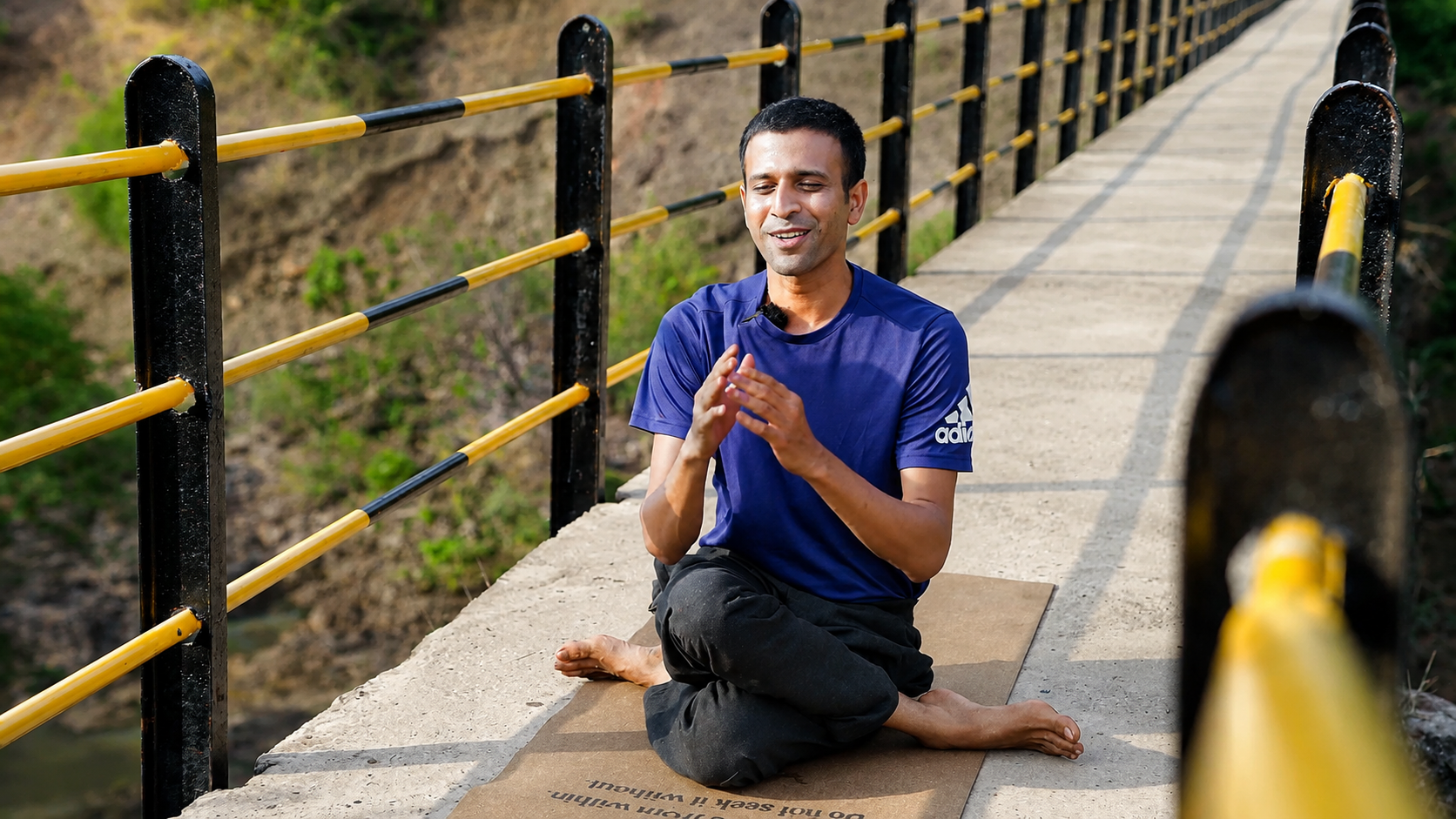 Amogh Shinde seated in meditation by a walkway