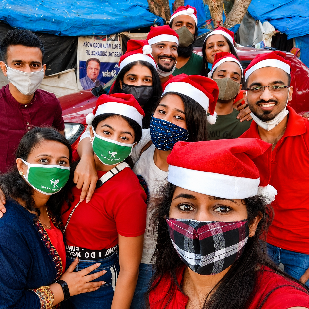 Volunteers and children celebrating together, some in Santa hats