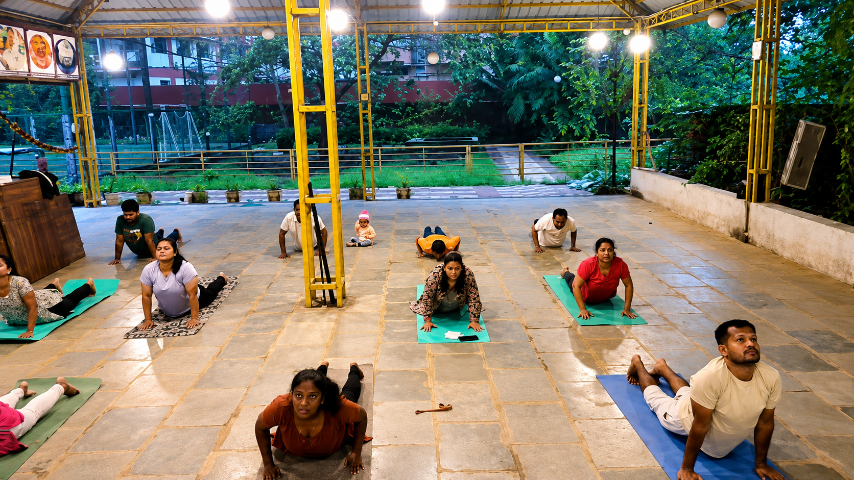 Group yoga class practicing on the courtyard in the evening