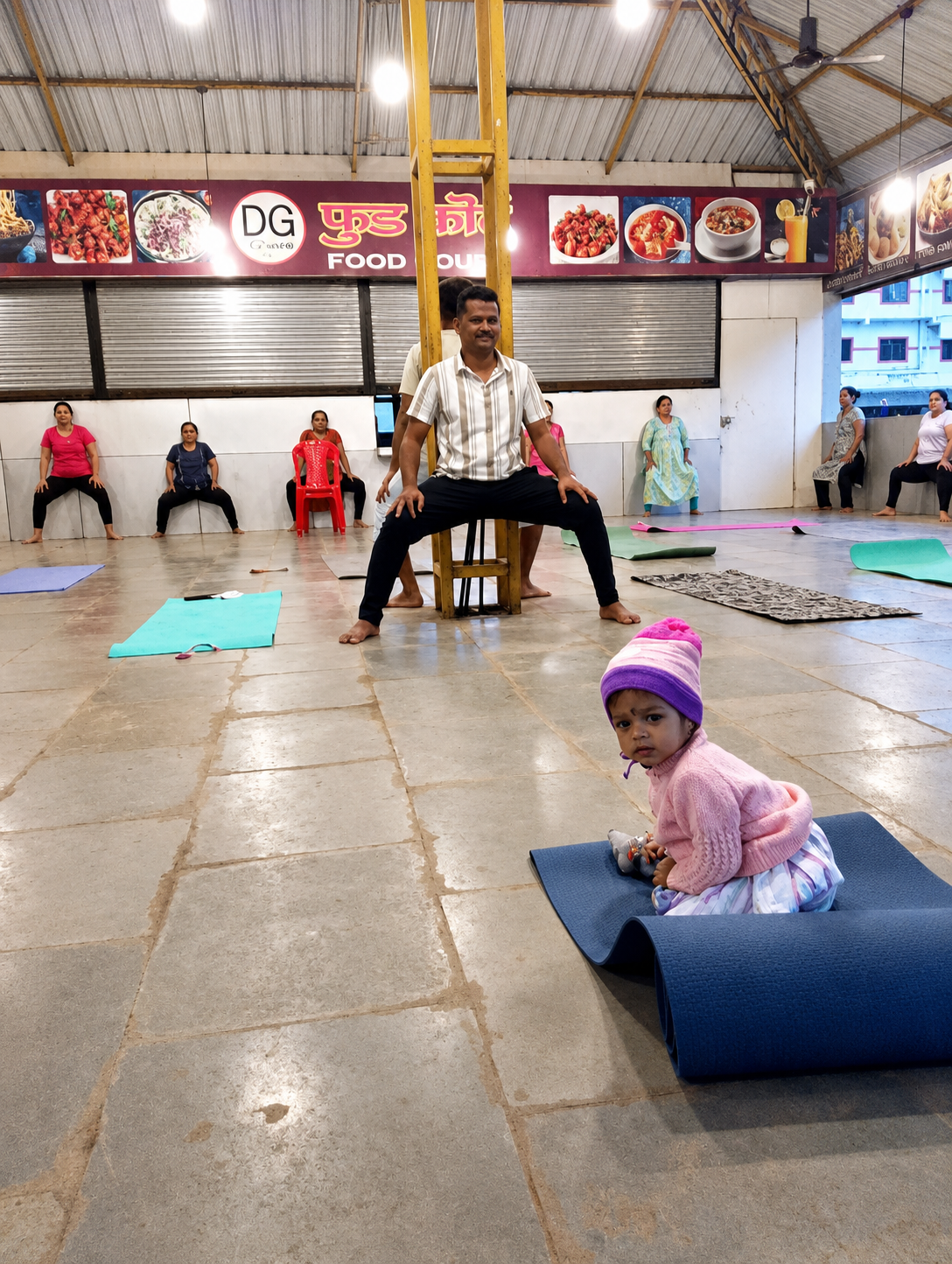 Instructor assisting a student with an inversion pose indoors