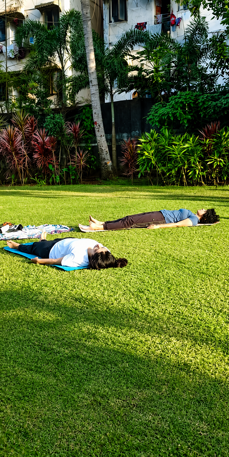 Participants resting in a relaxation pose on the grass