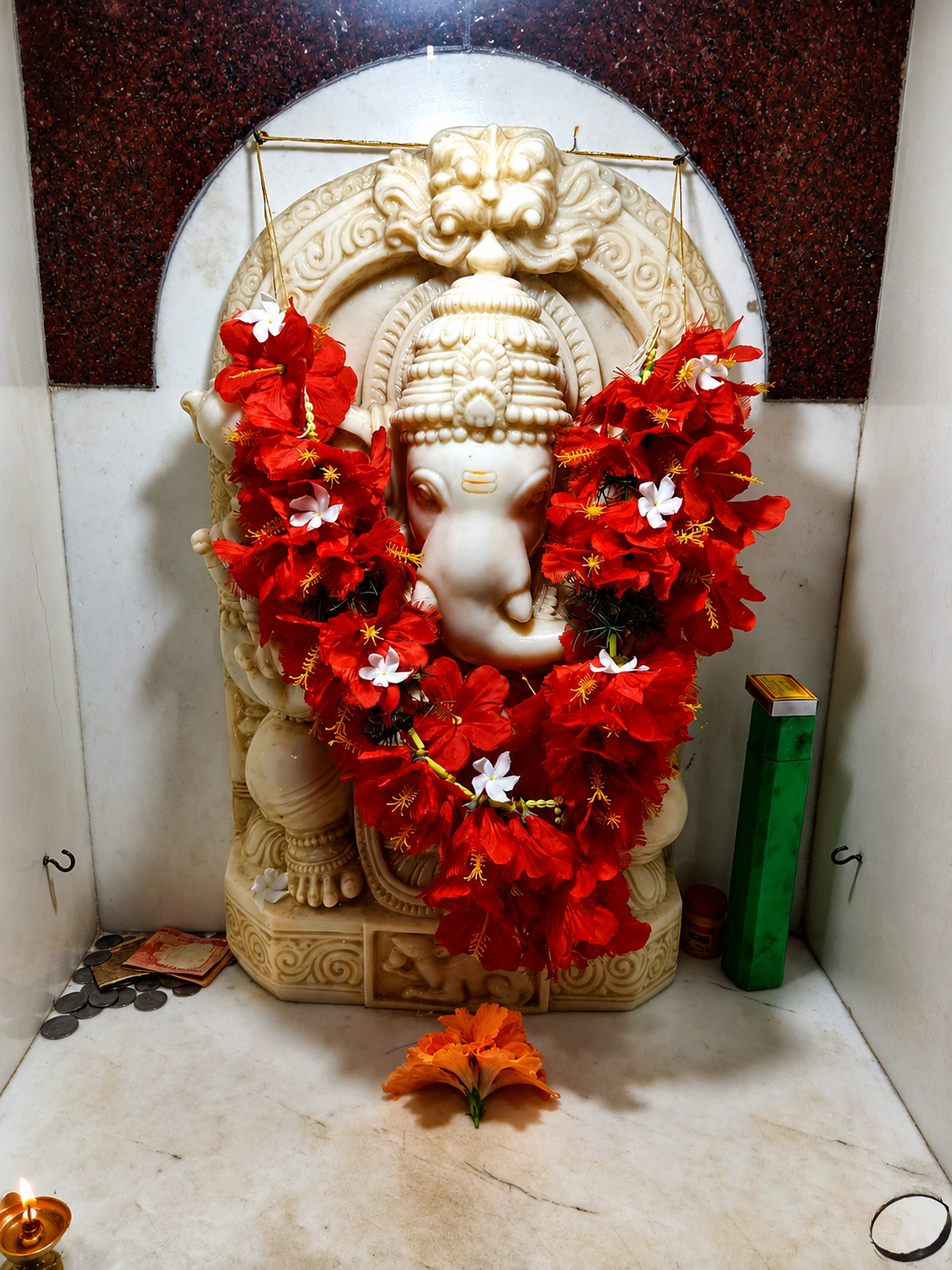 Ganesh idol decorated with red flowers