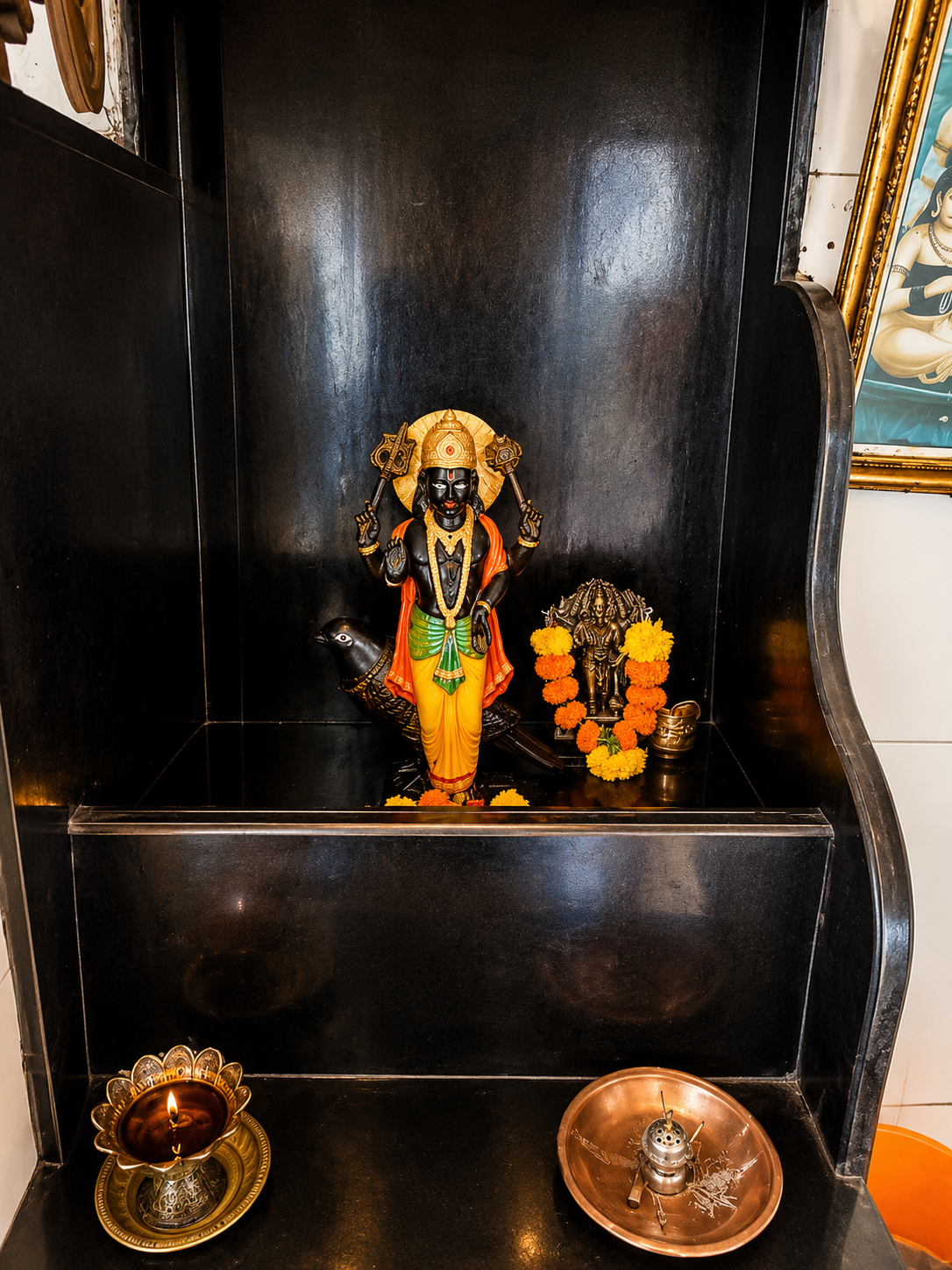 Deity idol placed inside a dark wooden shrine